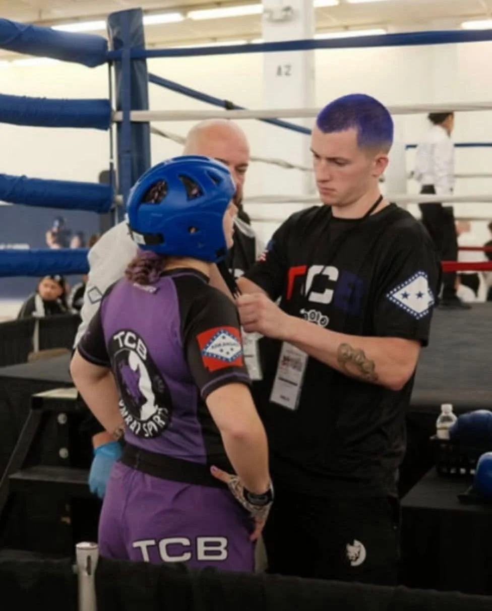 A coach and fighter prepare together at ringside.