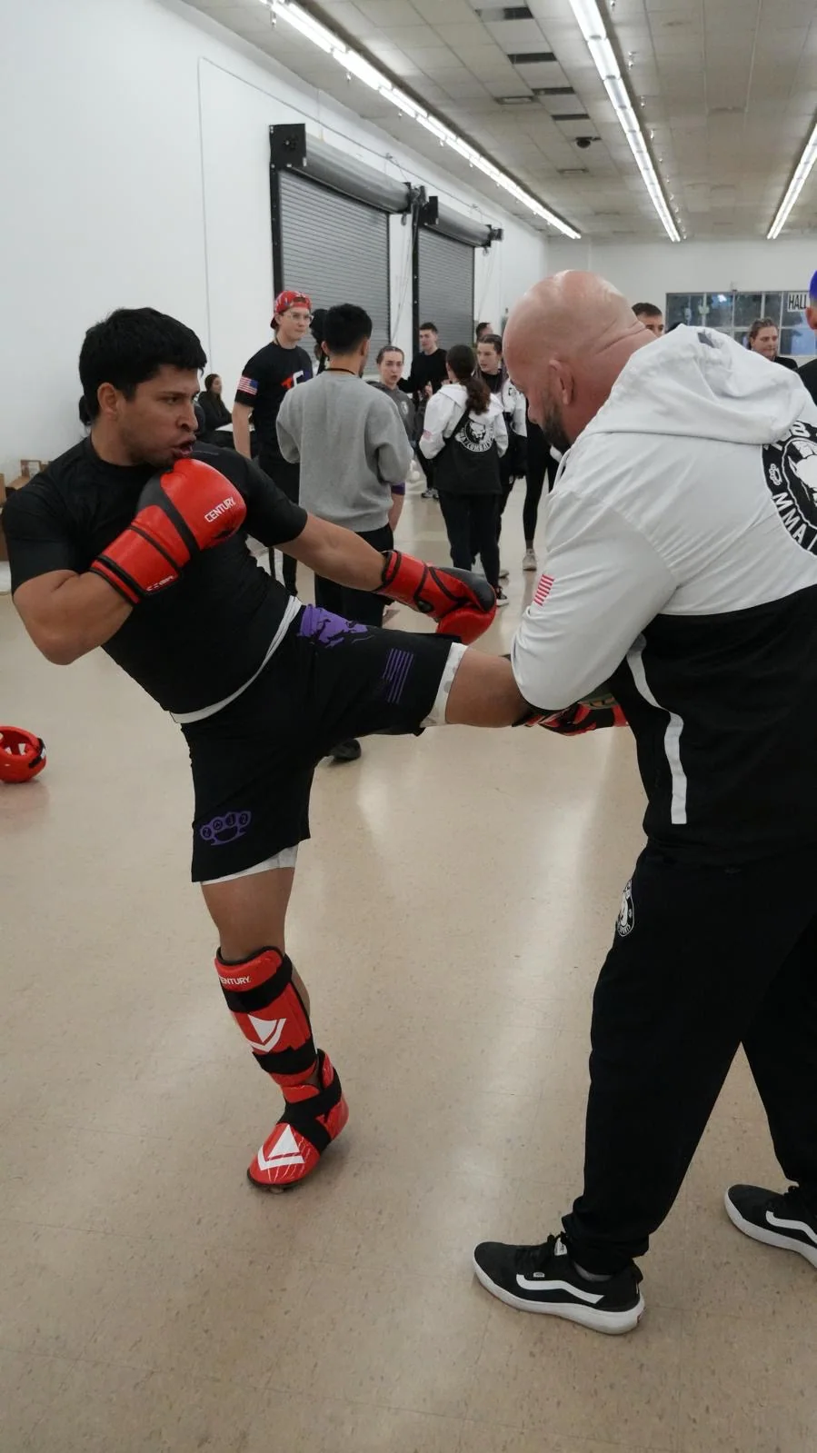 A TCB coach and athlete working together during a striking session